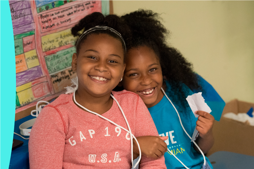 Girls smiling with Achieve Miami t-shirt
